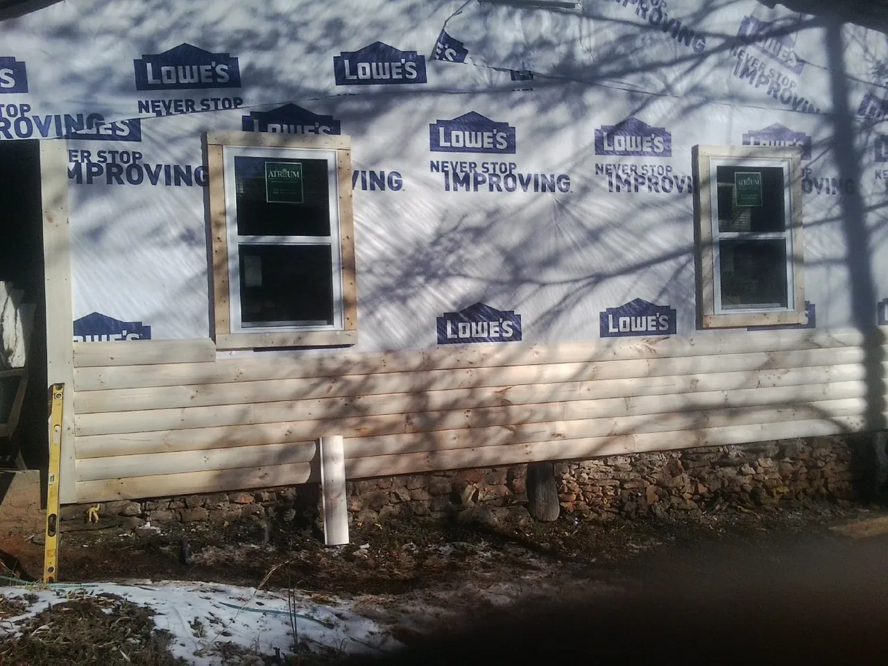 House wrap and new log siding going up on an exterior wall in Hamden