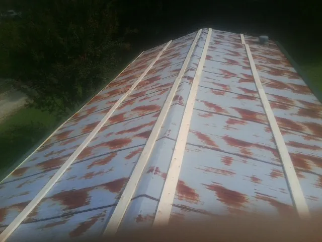 Rusted metal roof panels with new wood purlins before replacement — Storm Damage Roof Repair in Hamden by Roofing Brothers