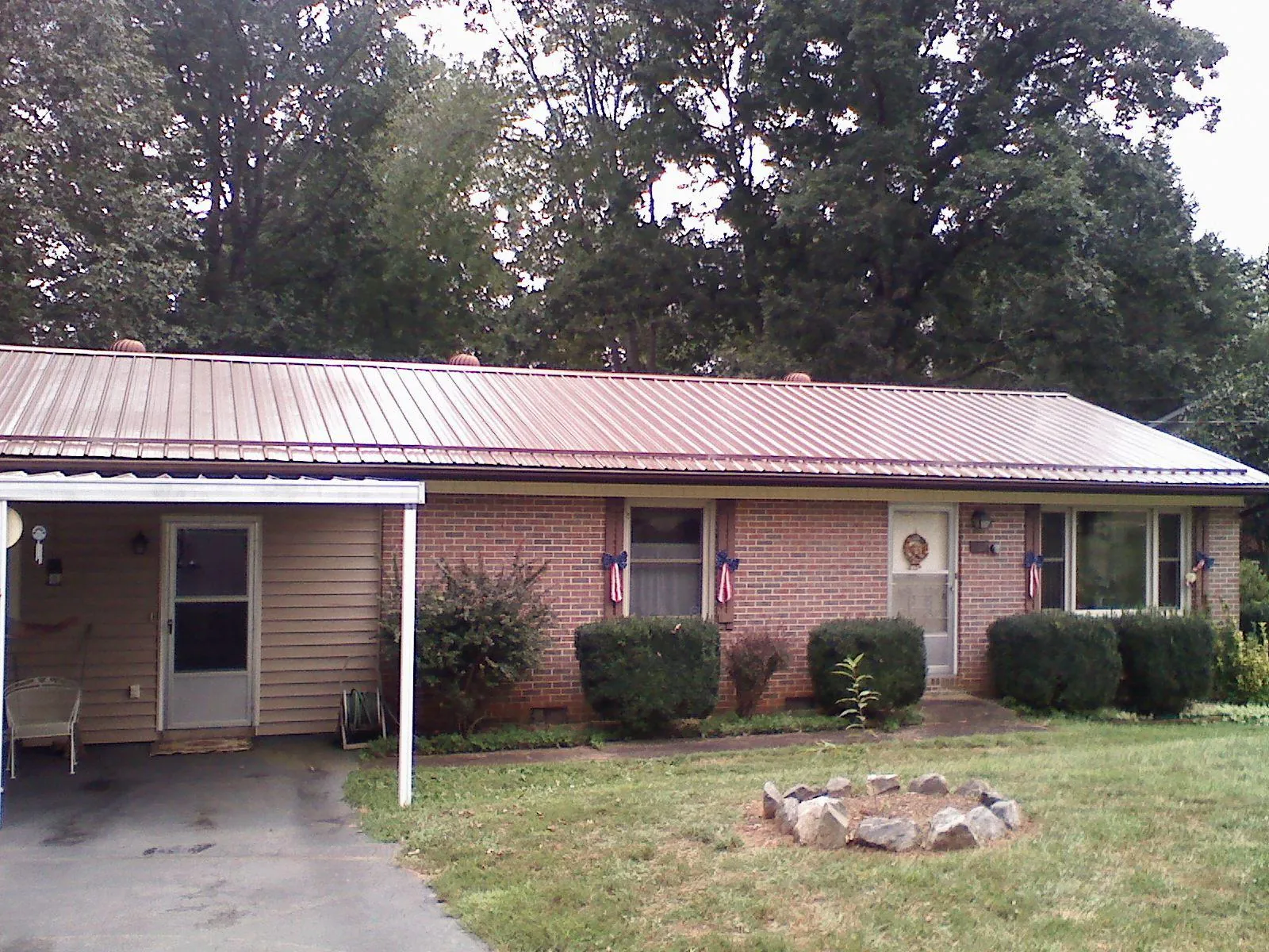 Bronze metal roof and carport on a brick ranch home — Roof Repair work by our crew in Hamden